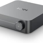 Compact modern audio amplifier device on white background.